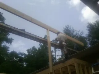 Carpenter setting a ridge beam over a new addition frame — Ice Dam Removal by Roofing Brothers in Jonesborough