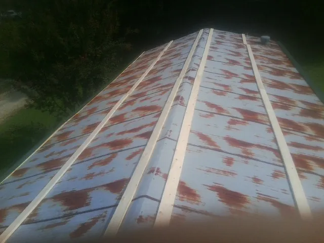 Rusted metal roof panels with new wood purlins before replacement — Storm Damage Roof Repair in Jonesborough by Roofing Brothers