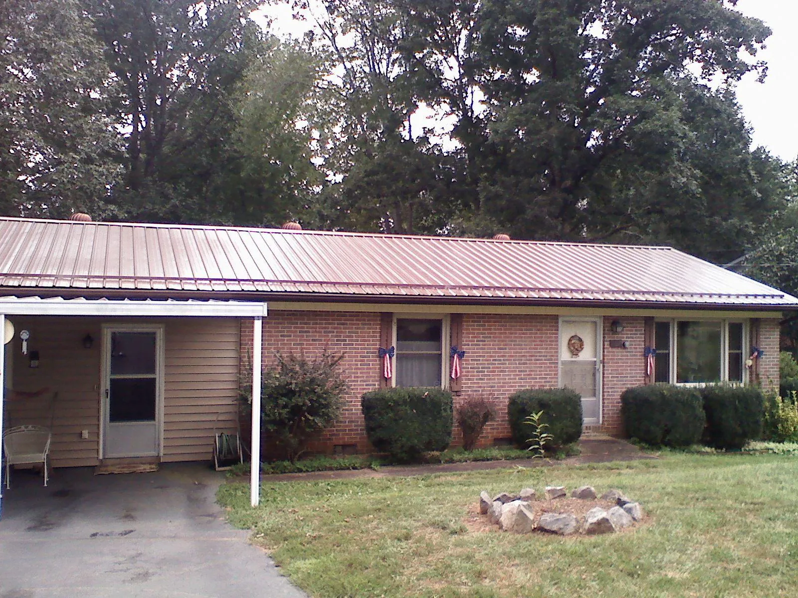 Bronze metal roof and carport on a brick ranch home — Roof Repair work by our crew in Jonesborough